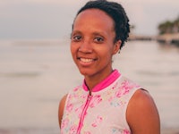 a woman smiling in front of the ocean