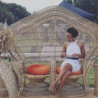 a woman sitting on a wicker chair